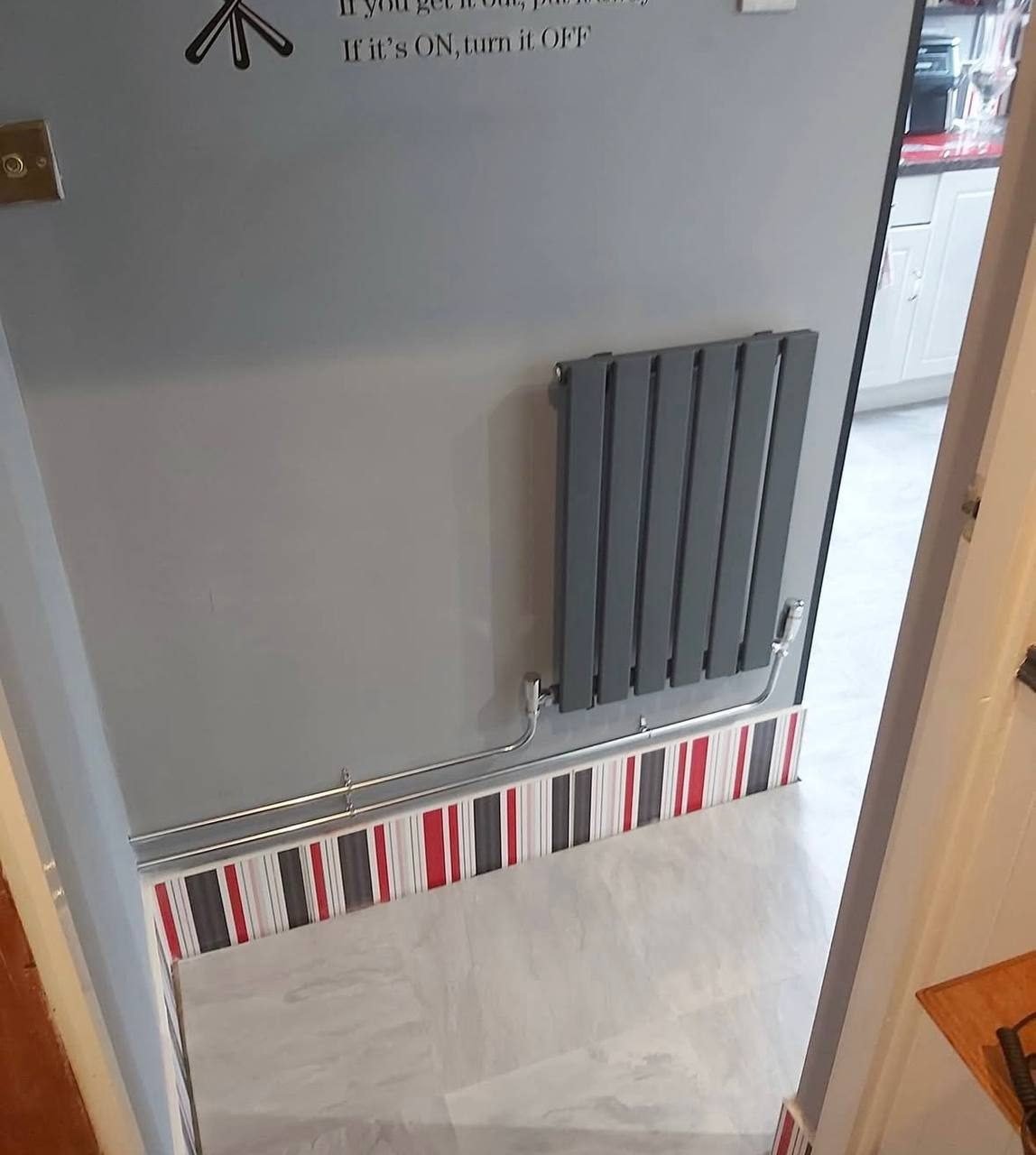 Horizontal anthracite panel radiator with chrome valves and neat pipe runs