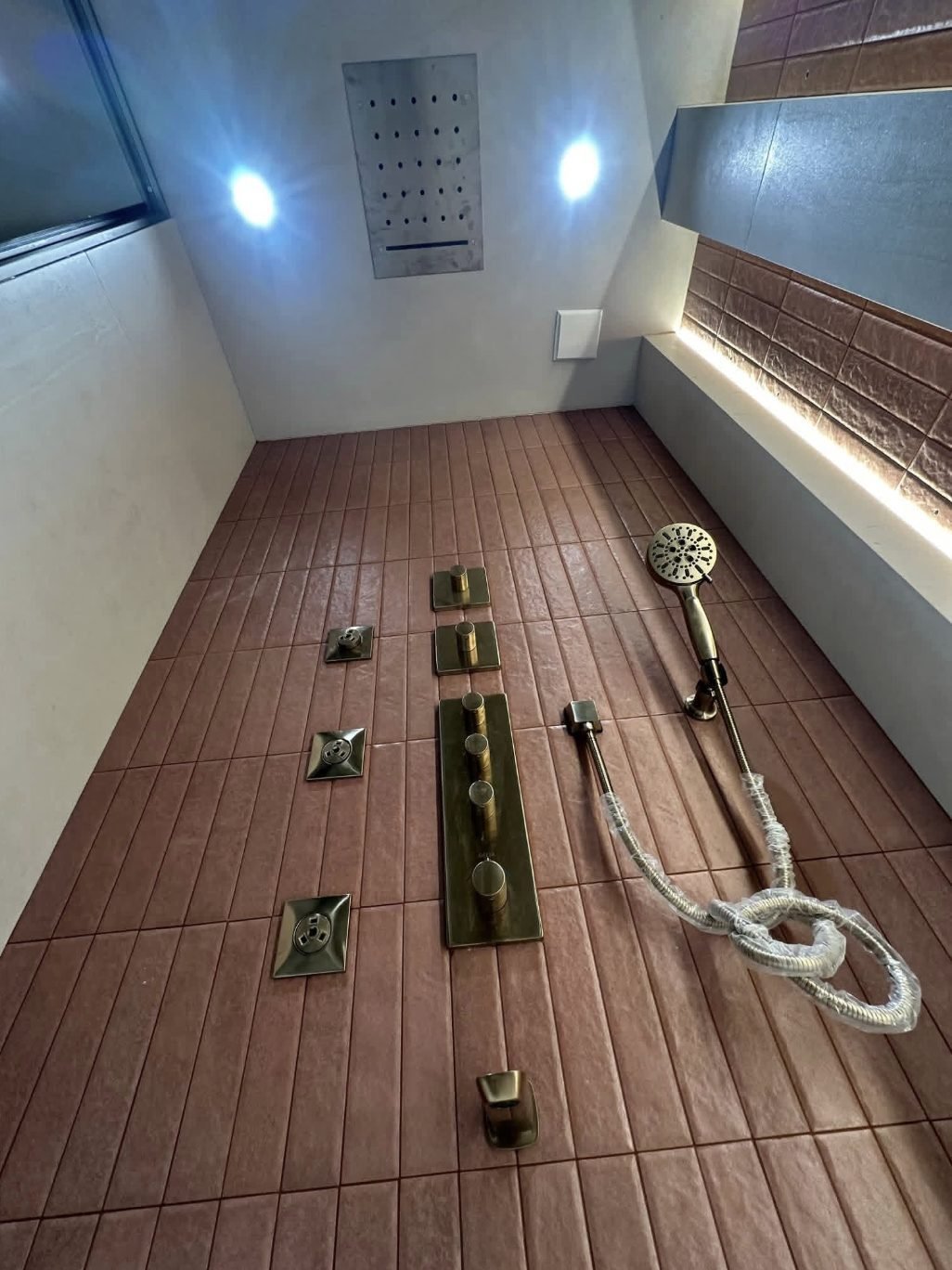 Gold body-jet shower system with ceiling drencher head and recessed lighting