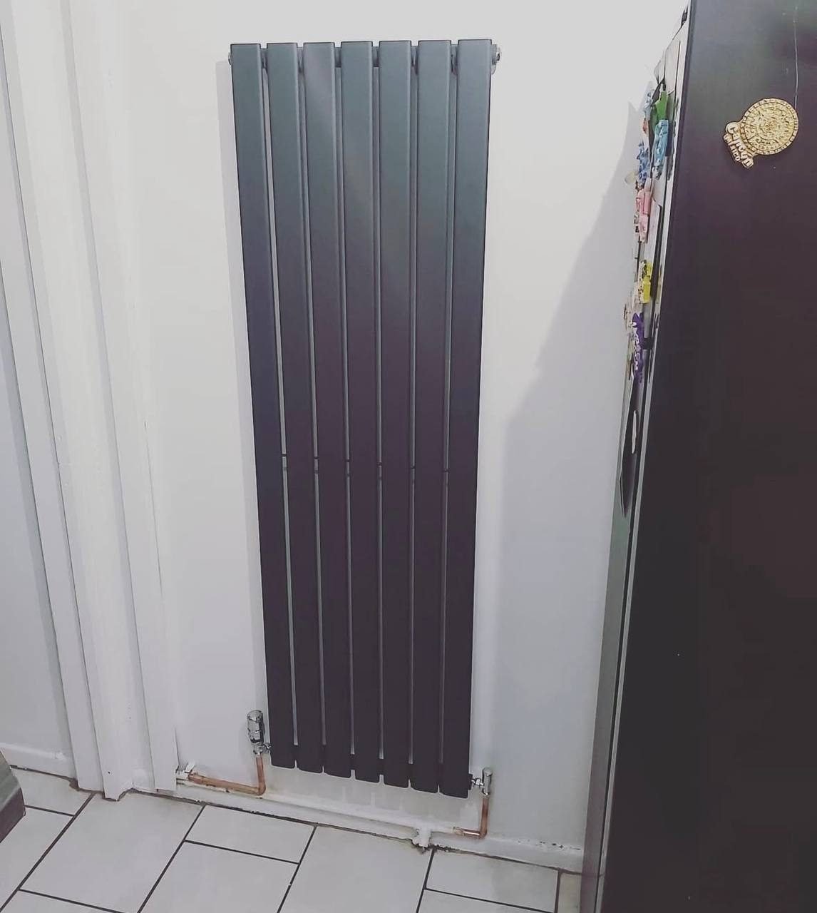 Anthracite vertical designer radiator fitted in a hallway